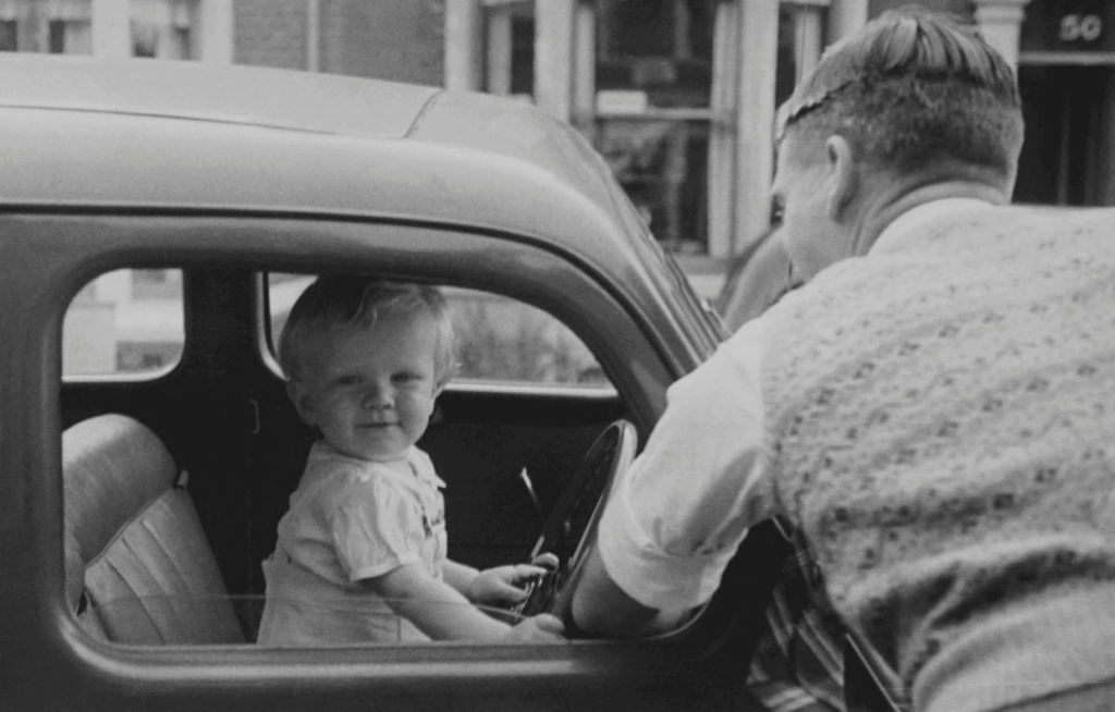 Captured moment of a little boy in the driver's seat of his dad's car